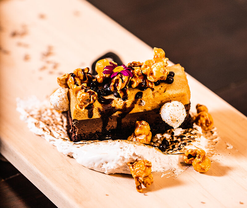 Plated chocolate dessert with caramel popcorn on a wooden board